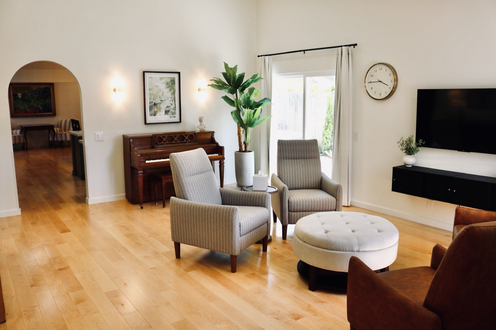 Bright, comfortably furnished living room with lit wall sconces